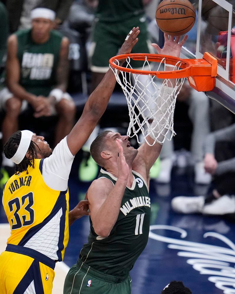 Milwaukee Bucks' Brook Lopez (11) shoots against Indiana Pacers' Myles Turner (33) during the first half of Game 4 of the first round NBA playoff basketball series, Sunday, April 28, 2024, in Indianapolis. (AP Photo/Michael Conroy)