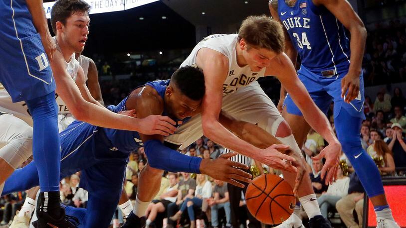 Duke forward Javin DeLaurier, center left, battles Georgia Tech's Ben Lammers, center right, and Evan Cole, back left, for the ball in the second half of an NCAA college basketball game Sunday, Feb. 11, 2018, in Atlanta. (AP Photo/John Bazemore)