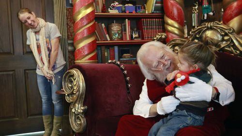 Debbie McGaw watches as her son, Noah, 2, reluctantly visits with Santa at North Point Mall in Alpharetta. Consumers are increasingly buying Christmas gifts online, but Santa visits help draw parents of young kids to malls across the nation. BOB ANDRES /BANDRES@AJC.COM