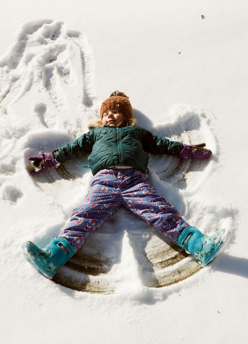    Greer Glover, 3, makes a snow angel at Ansley Golf  in Atlanta.  She was there with her mother, Melissa.   BOB ANDRES  /BANDRES@AJC.COM