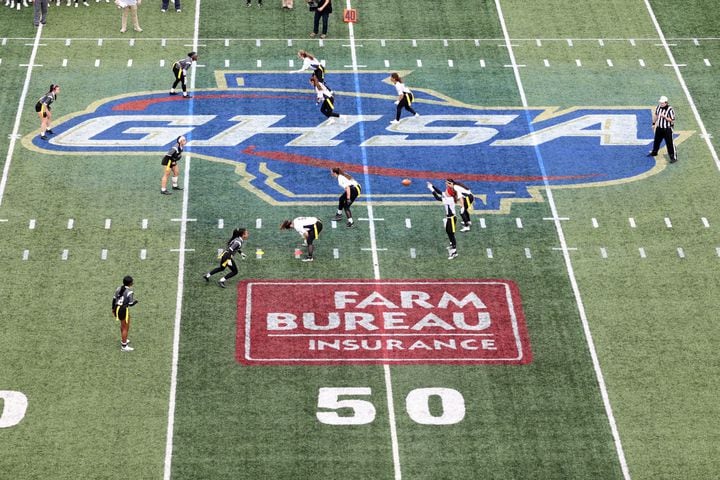 With the GHSA logo on the field, West Forsyth quarterback Haylee Dornan receives the snap in the first half against Hillgrove during the Class 6A-7A Flag Football championship at Center Parc Stadium Monday, December 28, 2020 in Atlanta, Ga.. JASON GETZ FOR THE ATLANTA JOURNAL-CONSTITUTION