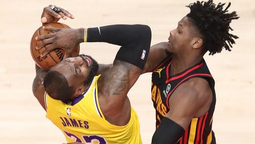 Foul on the play: Hawks forward Cam Reddish hits LeBron James with a hard foul during the early portion of Monday's Hawks-Lakers matchup at State Farm Arena.