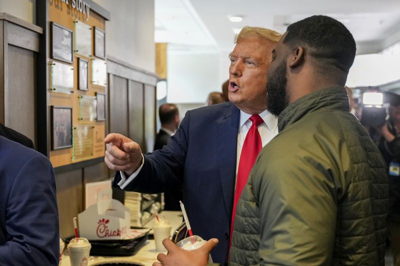 Republican presidential candidate former President Donald Trump, left, greets a customer as he visits a Chick-fil-A eatery, Wednesday, April 10, 2024, in Atlanta. (AP Photo/Jason Allen)