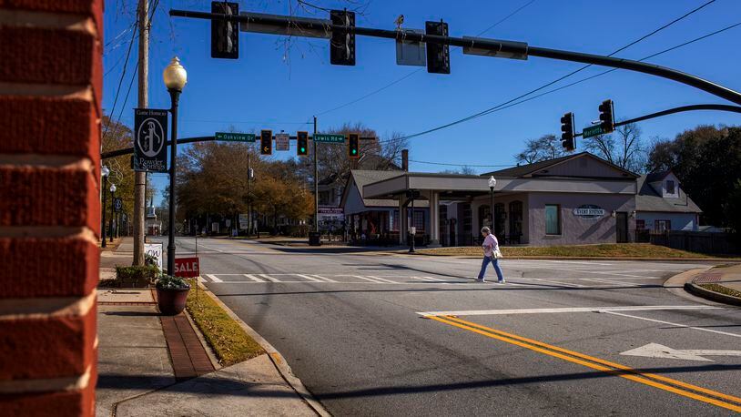 Shirley Brassell of Austell, Georgia, walks across Marietta Street in Powder Springs, Georgia, on Thursday, December 10, 2020. Brassell visits Powder Springs often to get her hair done and is excited to see the town continue to develop. Powder Springs is embarking on a plan that would allow more businesses and mixed-used residences to possibly open in its downtown. The city's plan hopes to promote growth and redevelopment while maintaining its small-town charm and atmosphere. (Rebecca Wright for the Atlanta Journal-Constitution)  