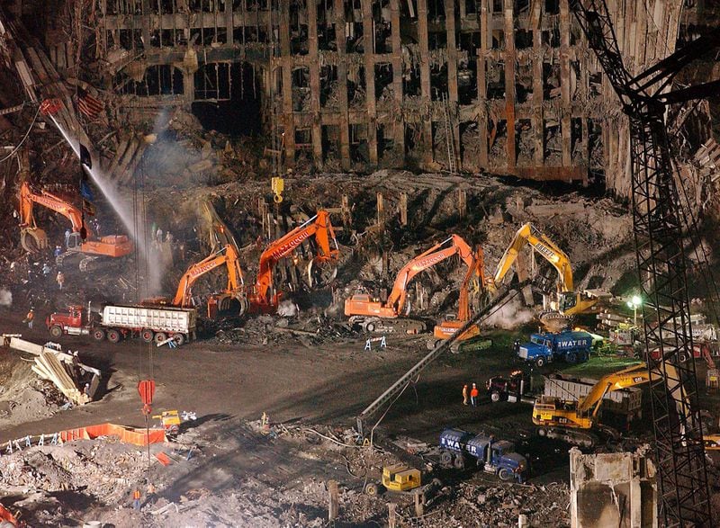 Workers and heavy machinery continue the cleanup and recovery effort in front of the remaining facade of One World Trade Center at ground zero in November 2001. The clearing of the debris took months. (File photo)