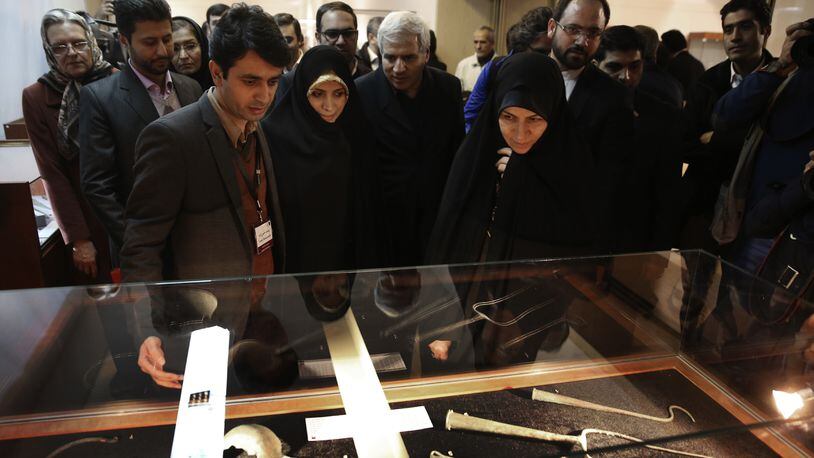 In this photo taken on Monday, Feb. 6, 2017, chief of Iran's Cultural Heritage, Handicrafts and Tourism Organization Zahra Ahmadipour, right, and Special Assistant to the Iranian President on Citizenship Rights Elham Aminzadeh, center left, look at artifacts during the opening of a show displaying some 550 ancient Persian artworks returned by Western countries, including the United States, at Iran National Museum in Tehran, Iran. (AP Photo/Vahid Salemi)