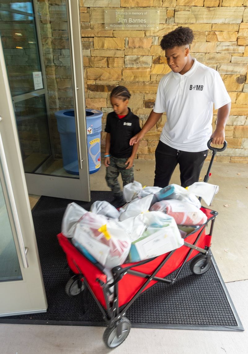 C.J. Matthews (right) age 16, and his brother Kollin, 7, make a delivery to the Ronald McDonald House as part of their Blankies 4 My Buddies nonprofit.  PHIL SKINNER FOR THE ATLANTA JOURNAL-CONSTITUTION