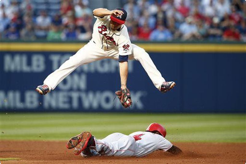 Jace Peterson, here avoiding a slide by the Reds' Brandon Phillips, has played solid defense and raise his average above .290 with a 15-game surge. (AP photo)