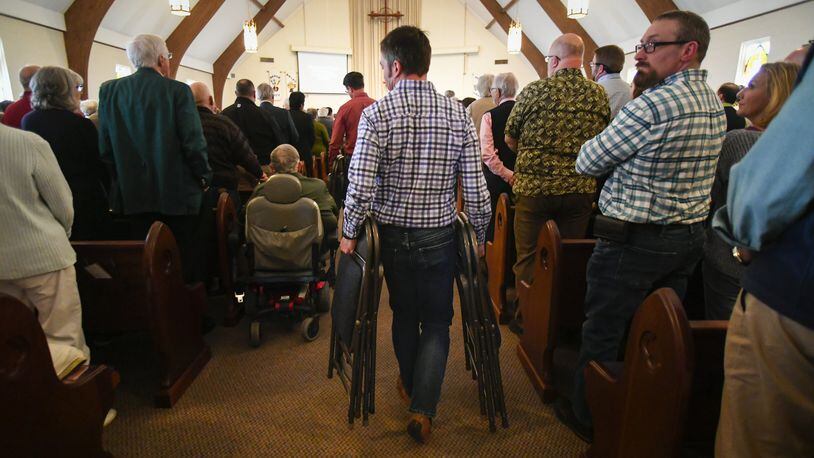 A volunteer brings extra seats into the sanctuary as clergy, laity, and members meet for a district gathering of The United Methodist Church, held at Kennesaw United Methodist Church on March 17, 2019. The UMC voted to maintain and strengthen its stance against gay marriage and gay clergy during a special session of the General Conference in February. This meeting provided a chance for members to hear and ask questions., take communion together, and worship. JOHN AMIS/for the AJC