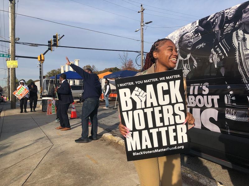 Community activists hold a get-out-the-vote event near a polling station in southwest Atlanta during early voting on Thursday in Georgia’s runoff between Democratic Sen. Raphael Warnock and Republican Herschel Walker. (Jenny Jarvie/Los Angeles Times/TNS)