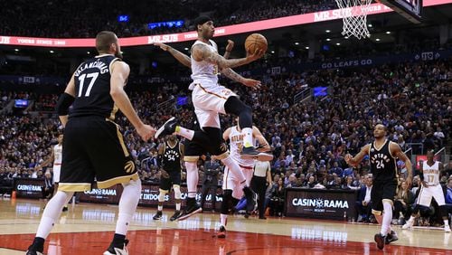 Mike Scott of the Atlanta Hawks drives to the basket as Jonas Valanciunas (17) and DeMar DeRozan (10) of the Toronto Raptors defend during the second half of an NBA game at the Air Canada Centre on March 30, 2016 in Toronto, Ontario, Canada. (Photo by Vaughn Ridley/Getty Images)