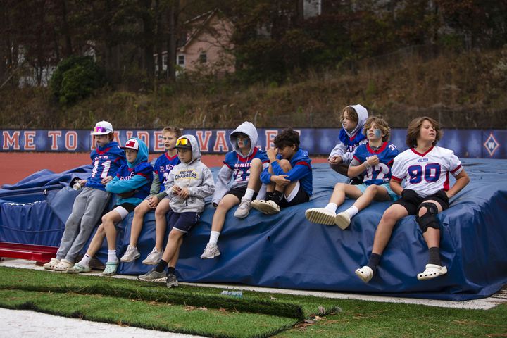 Young Walton football team fans sit on the sidelines. CHRISTINA MATACOTTA FOR THE ATLANTA JOURNAL-CONSTITUTION.