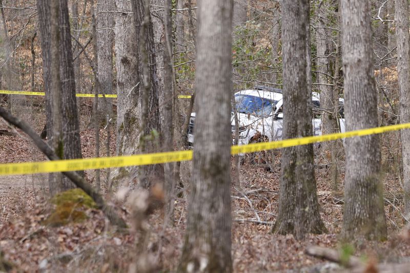 A University of Georgia Police vehicle is shown near police tape that ropes off the crime scene on a trail behind Lake Herrick in Athens at the University of Georgia on Friday, Feb. 23, 2024. A female nursing student was found dead nearby on Thursday. (Jason Getz / jason.getz@ajc.com)