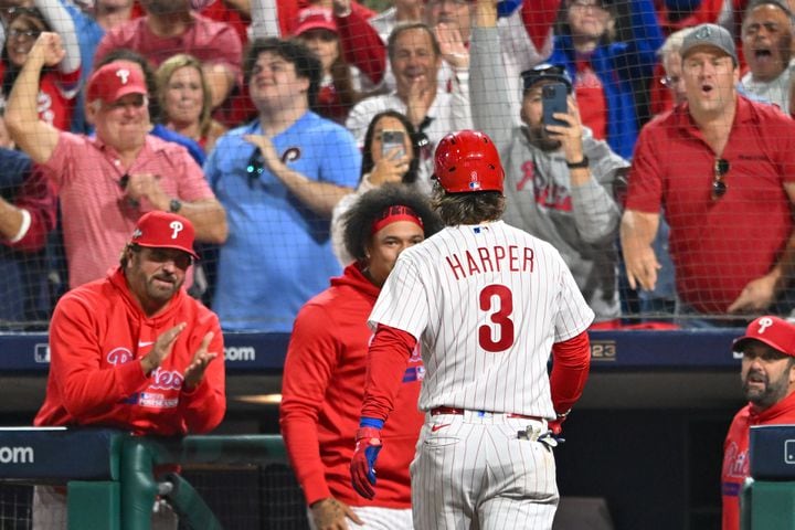 Philadelphia Phillies’ Bryce Harper is welcomed by teammates after hitting his second home run of the evening during the fifth inning of NLDS Game 3 against the Atlanta Braves in Philadelphia on Wednesday, Oct. 11, 2023.   (Hyosub Shin / Hyosub.Shin@ajc.com)