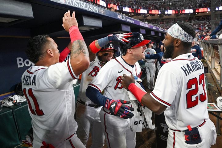 Atlanta Braves’ Orlando Arcia (11) and Michael Harris II (23) celebrate with Austin Riley after his two-run home run against the Philadelphia Phillies during the eighth inning of NLDS Game 2 in Atlanta on Monday, Oct. 9, 2023.   (Hyosub Shin / Hyosub.Shin@ajc.com)