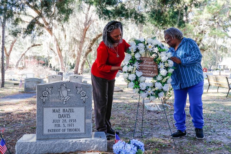 Jannie Everette, CEO/President of the Thiokol Memorial Project, and Emma Lou Gibbs reposition a wreath at the grave of Mae Hazel Davis, one of the victims of the 1971 explosion at Thiokol.