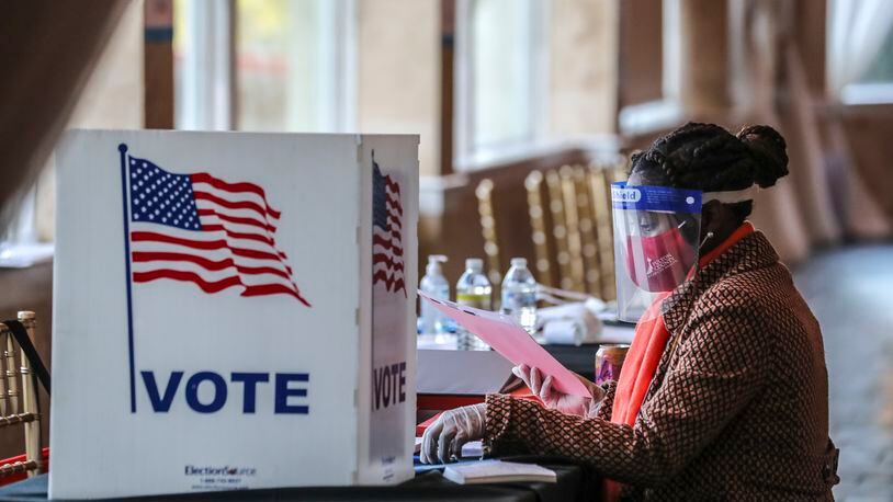 A poll worker sorts through voting material at Park Tavern in Atlanta on Election Day, Tuesday, Nov. 3, 2020. (John Spink / John.Spink@ajc.com)