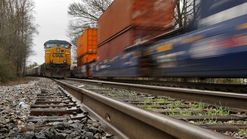 FILE PHOTO: A CSX train is stationary (left) as another train passes at the Stanley Road crossing in Kennesaw. (John Spink, jspink@ajc.com)