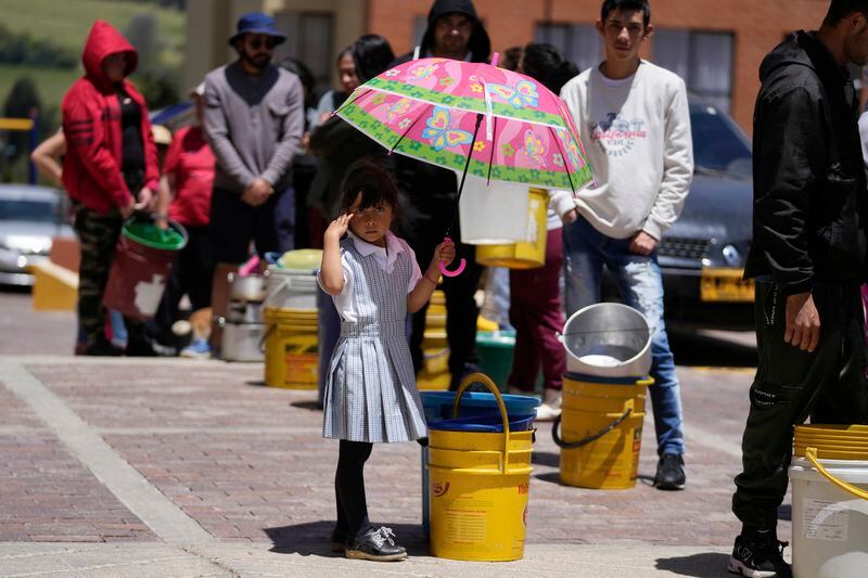 Residents line up to collect water from a truck amid water rationing in La Calera, on the outskirts of Bogota, Colombia, Tuesday, April 16, 2024. Amid a drought linked to the El Niño weather pattern, several regions of Colombia have adopted measures to curb water consumption while reservoirs are low. (AP Photo/Fernando Vergara)