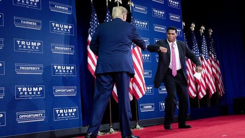 University of Georgia football legend Herschel Walker, right, shown greeting President Donald Trump at an event at the Cobb Galleria Centre in Atlanta in September, is flirting with a run as a Republican for the U.S. Senate, and he's made an issue out of voter fraud. Walker's wife, Julie Blanchard, cast a vote in Georgia's presidential election last fall even though the couple lives in Texas and claims a homestead exemption there. (Brendan Smialowski/AFP via Getty Images/TNS)