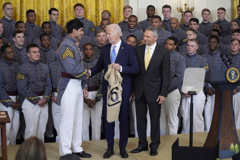 President Joe Biden is presented a team jersey by team captain Jimmy Ciarlo, as head coach Jeff Monken, right, looks on, during an event to present the Commander-in-Chief's Trophy to the United States Military Academy Army Black Knights, in the East Room of the White House, Monday, May 6, 2024, in Washington. (AP Photo/Evan Vucci)