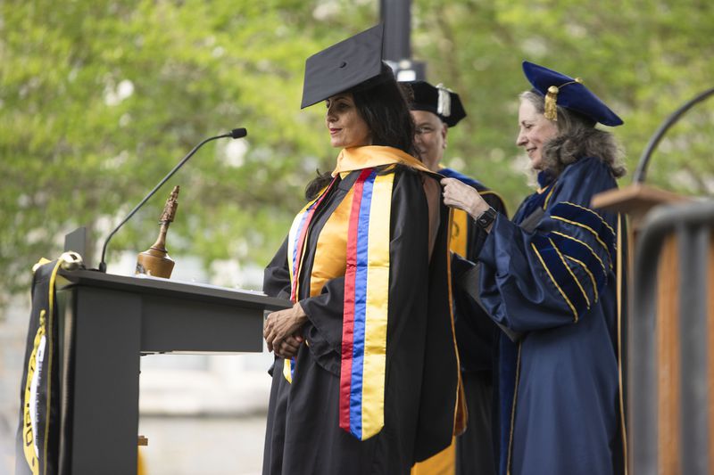 Oglethorpe University's then-Provost Kathryn McClymond (right) confers an honorary doctorate degree to Andrea Rivera (left) during the commencement ceremony on May 20, 2023. McClymond has been named the university's president. (Christina Matacotta / AJC file photo)