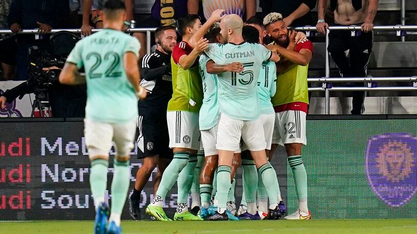 Atlanta United players celebrate as they surround midfielder Thiago Almada after he scored a goal against Orlando City during the second half of an MLS soccer match Wednesday, Sept. 14, 2022, in Orlando, Fla. (AP Photo/John Raoux)