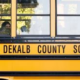 A student waits in the bus, ready to get out during the first day of school for DeKalb County public schools at Cross Keys High School in Atlanta on Monday, Aug. 8, 2022. The modernization of Cross Keys High is among the projects being prioritized over the building of two new schools. (Miguel Martinez / miguel.martinezjimenez@ajc.com)