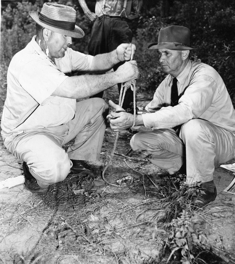Loy Harrison (left), a witness to the Moore’s Ford murders, shows then-Sheriff J.M. Bond of Oconee County how a mob of white men bound the hands of two black men together before shooting them and their wives to death near Monroe, Ga., July 25, 1946. Authorities suspected that Harrison was complicit in the crime. (Associated Press Photo)
