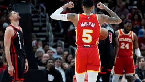 Atlanta Hawks guard Dejounte Murray (5) celebrates after forward Bruno Fernando, right, scored a basket as Chicago Bulls center Nikola Vucevic, left, reacts during the second half of an NBA basketball game in Chicago, Monday, April 1, 2024. The Hawks won 113-101. (AP Photo/Nam Y. Huh)