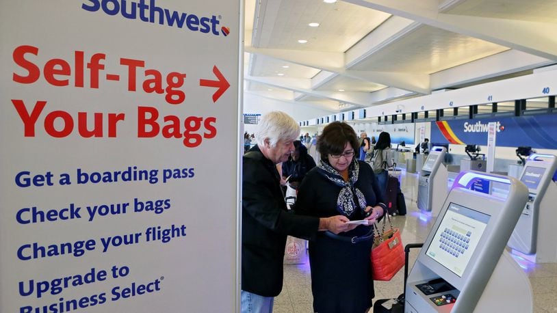 Leslie Smith, of Roswell, and her father Robert Bristol, of New York, use Southwest Airlines’ self-tag kiosk at the Atlanta airport. The kiosks allow travelers to print out their own bag tags and apply them to their luggage — one of the latest examples of technology to enable self-processing by airline passengers. BOB ANDRES /BANDRES@AJC.COM