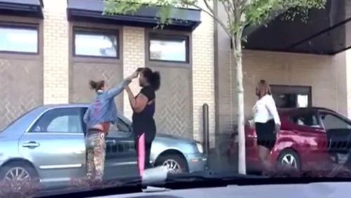 Video of a fight outside an Atlanta Chick-fil-A showed a woman pull a gun on another and hold it against her forehead.