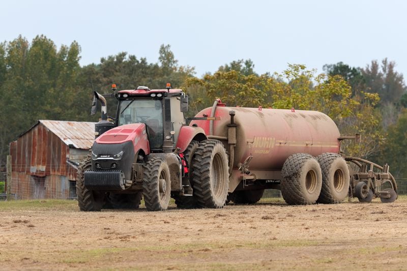 A tractor mounted with a tank used to apply a soil amendment is seen on a field near the town of Mitchell on Wednesday, October 12, 2022.   (Arvin Temkar / arvin.temkar@ajc.com)