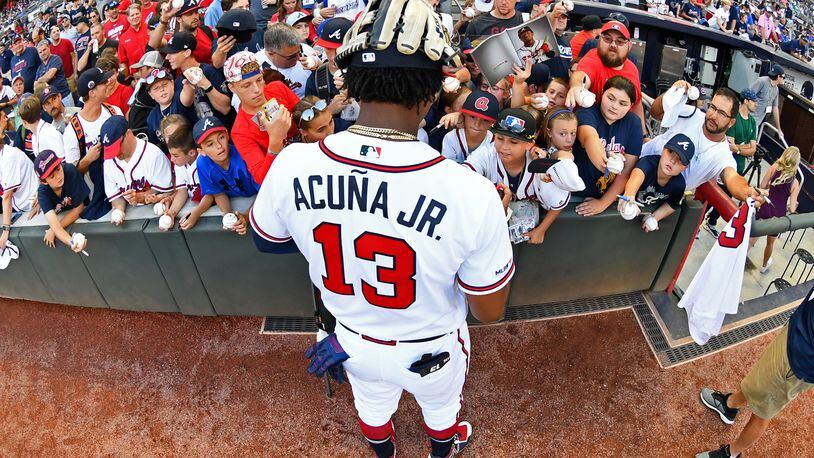 The Braves’ Ronald Acuna  signs autographs before the game against  Kansas City Royals at SunTrust Park on  Wednesday.