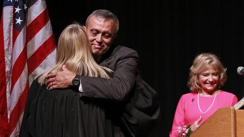 Mike Boyce hugs Cobb State Court Judge Marsha Lake after he was sworn in. At right is his wife, Judy. In a ceremony at the Cobb Civic Center, Mike Boyce was sworn in Friday as Cobb County’s next chair. BOB ANDRES /BANDRES@AJC.COM