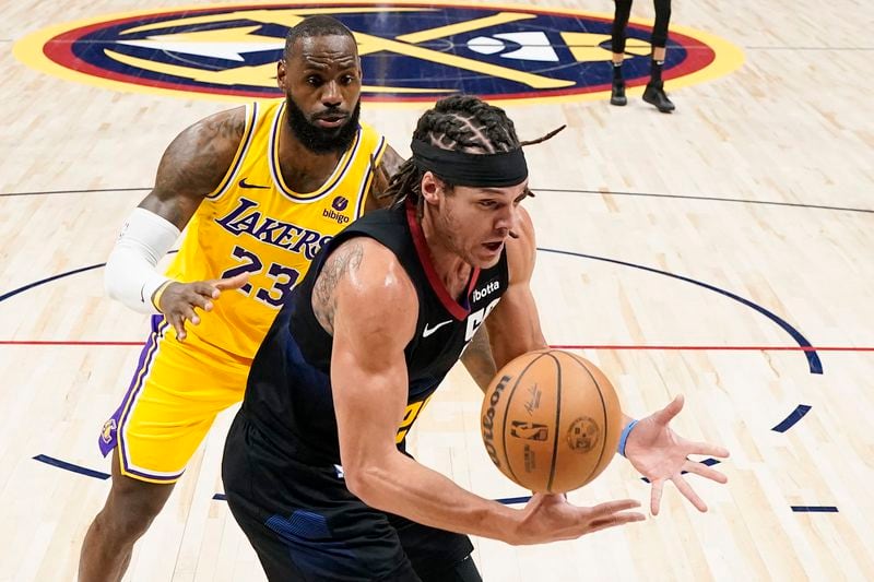 Denver Nuggets forward Aaron Gordon (50) grabs a loose ball against Los Angeles Lakers forward LeBron James (23) during the second half in Game 2 of an NBA basketball first-round playoff series, Monday, April 22, 2024, in Denver. (AP Photo/Jack Dempsey)