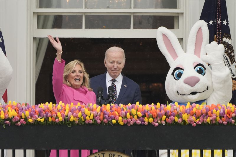 President Joe Biden and first lady Jill Biden, wave from the Blue Room Balcony toward The White House Easter Egg Roll on the South Lawn of the White House in Washington, Monday, April 1, 2024. A huge crowd descended on the White House lawn for the start of this year's Easter egg roll, after the event was delayed by thunder and lightning for about 90 minutes. More than 40,000 people, 10,000 more than last year, were expected to participate in Monday's event despite light rain. (AP Photo/Mark Schiefelbein)