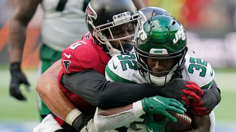 New York Jets running back Michael Carter (32) is tackled by Falcons defensive end Dante Fowler Jr. (6) during the first half Sunday, Oct. 10, 2021, at the Tottenham Hotspur stadium in London. (Alastair Grant/AP)