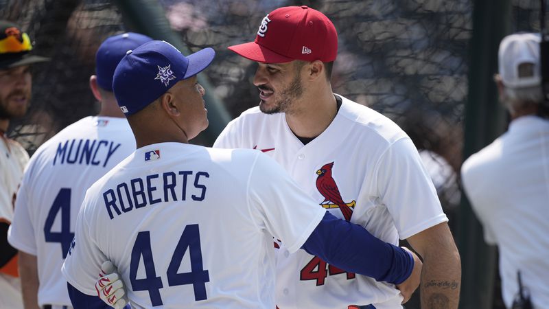 National League manager Dave Roberts greets Nolan Arenado during batting practice Monday at Coors Field in Denver. Roberts, the manager of the Dodgers, and other coaches and players wore No. 44 during workouts in honor of Hall of Famer and Braves legend Hank Aaron, who died in January.