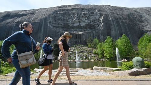 Parkgoers walk around the Memorial Lawn at Stone Mountain Park on Tuesday, April 20, 2021. The company that runs Stone Mountain Park no longer wants the gig, and it's been hard to find a replacement. (Hyosub Shin / Hyosub.Shin@ajc.com)