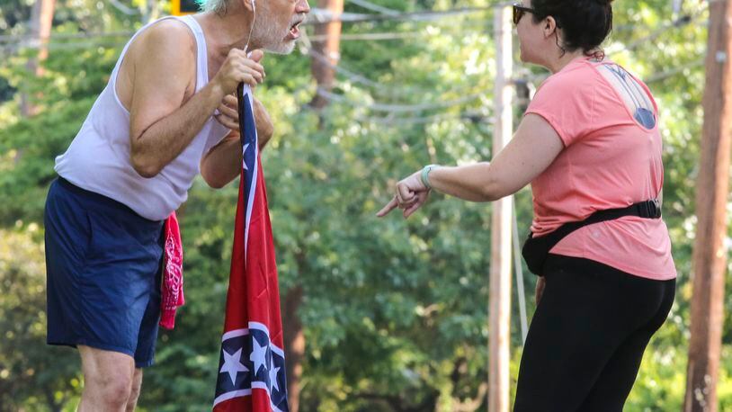 August 15, 2017 Atlanta: Confederate Flag runner Alan Keck (left) debates Grant Park resident Katie Kurumada (right) about the petition to change the name of Confederate Avenue on Tuesday, Aug. 15, 2017 on Boulevard. JOHN SPINK/JSPINK@AJC.COM