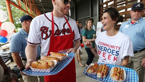 Jen Hidinger of Staplehouse and The Giving Kitchen and Atlanta Braves first baseman Freddie Freeman hand out free hot dogs (for donations) as she is honored as a Braves Community Hero. Curtis Compton/ccompton@ajc.com