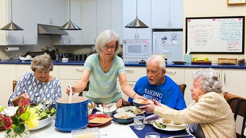 Carolyn Langenkamp, 68, helps serve the family-style dinner on Oct. 23, 2017. (Heidi de Marco/KHN)