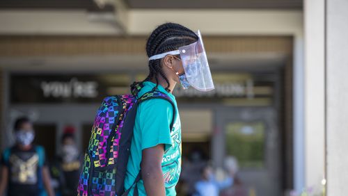A Clarkdale Elementary School student in Cobb County wears a face shield and a face mask while at school in Austell in October 2020. Overall, 14 metro Atlanta school districts have recorded nearly 79,000 cases so far in the 2021-2022 school year.  (Alyssa Pointer / AJC file photo)