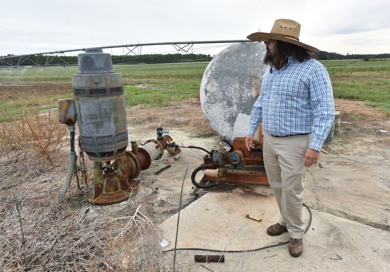 Christopher Worsham checks a well after turning on a farm irrigation system at his family farm in Vada in October 2019. (Hyosub Shin / Hyosub.Shin@ajc.com)