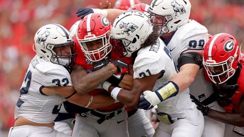 Georgia Bulldogs and running back Kendall Milton (2) found the going tough when it came to running the football against Samford this past Saturday. Here Milton fights for yardage against Samford's Noah Martin (32, left) and defensive back Isaiah Richardson (21) during the first quarter at Sanford Stadium, Saturday, September 10, 2022, in Athens. Georgia won 33-0. (Jason Getz / Jason.Getz@ajc.com)