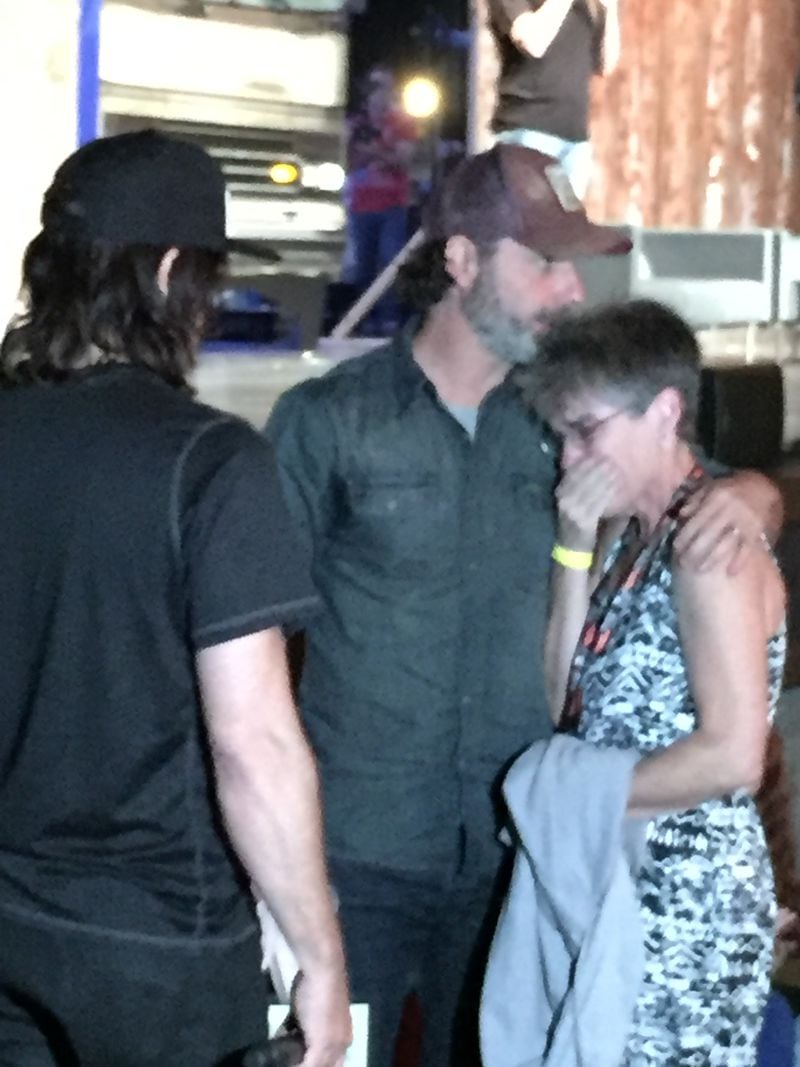 The Toronto fan gets comforted by Norman Reedus and Andrew Lincoln. CREDIT: Rodney Ho/rho@ajc.com