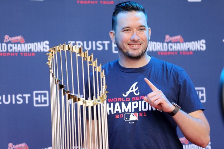 Joey Hnath poses beside the 2021 World Champions Trophy. Miguel Martinez for The Atlanta Journal-Constitution 