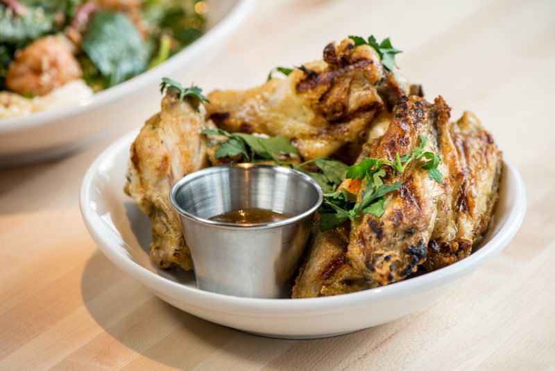 Charbroiled wings with spiced herb rub, ginger-honey sauce, and cilantro. Photo credit- Mia Yakel.