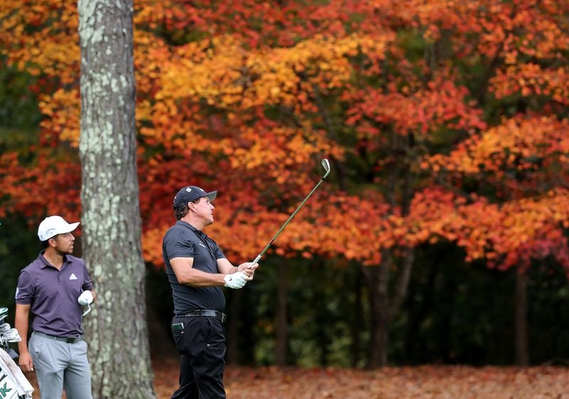 Fall leaves add some color to Augusta National Golf Club as Xander Schauffele watches Phil Mickelson’s fairway shot to the 11th green during Tuesday's practice round.